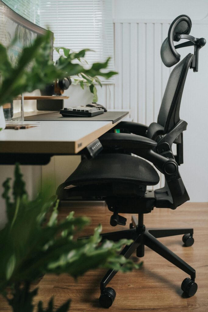 Ergonomischer Arbeitsplatz mit Pflanzen und großem Monitor – klare, strukturierte Arbeitsumgebung nach Feng Shui.